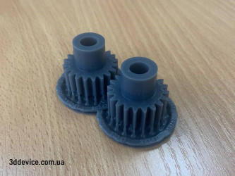 Two 3D-printed plastic gears, likely spur gears, used for transmitting motion.