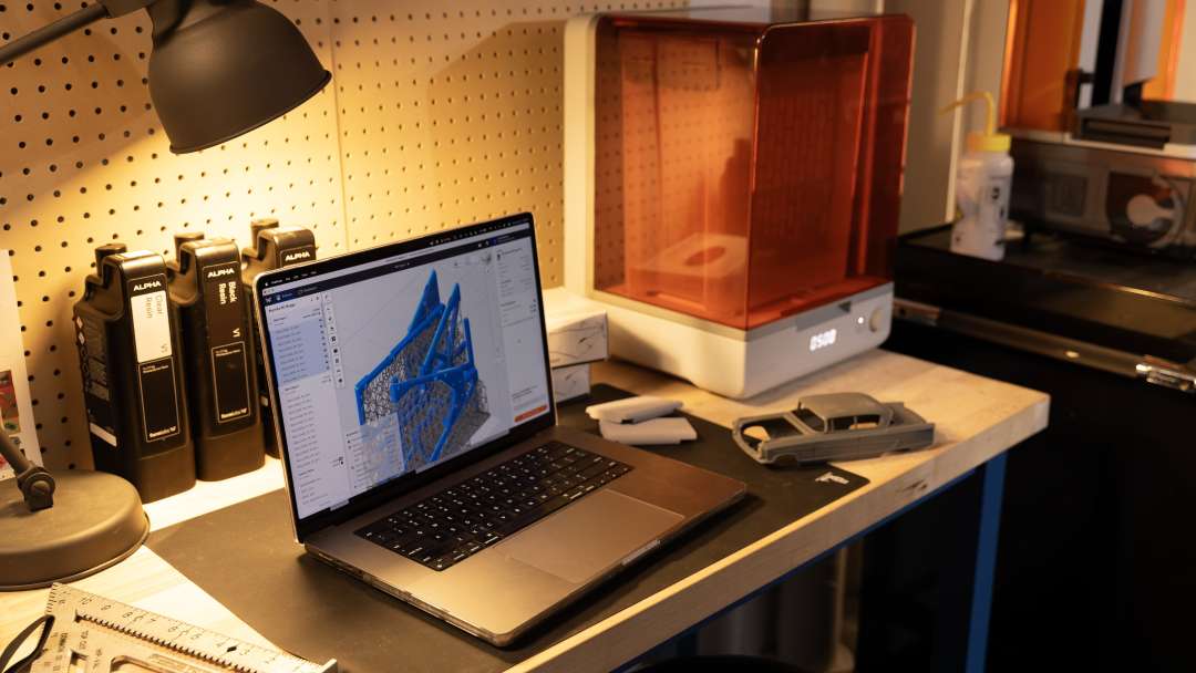 SLA 3D-принтер Formlabs с фотополимерными картриджами и напечатанной моделью автомобиля.