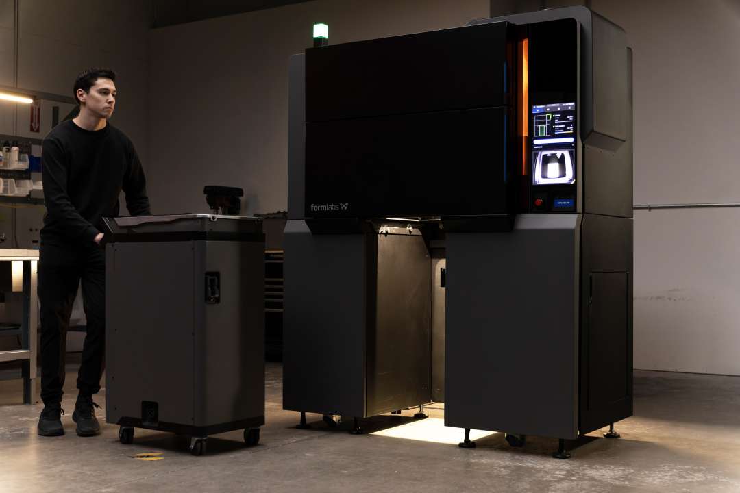 Технік викочує готовий колісний Блок Збірки Formlabs Fuse X1 з відкритого відсіку принтера для швидкого переналаштування