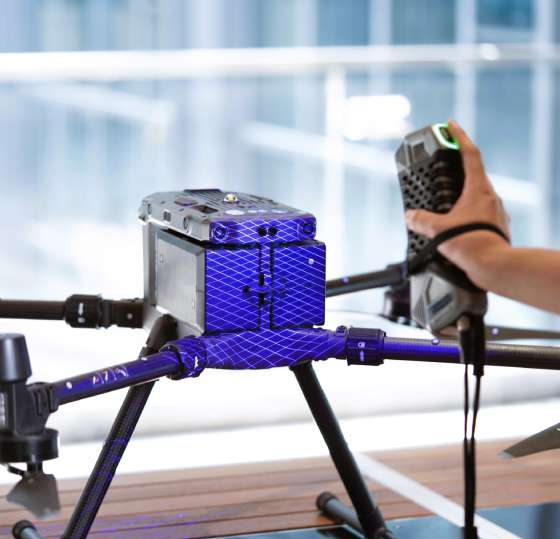 Scanology SimScan 42 Gen2 performing an ultra-fast scan of a car door, showcasing its 27 blue laser crosses.