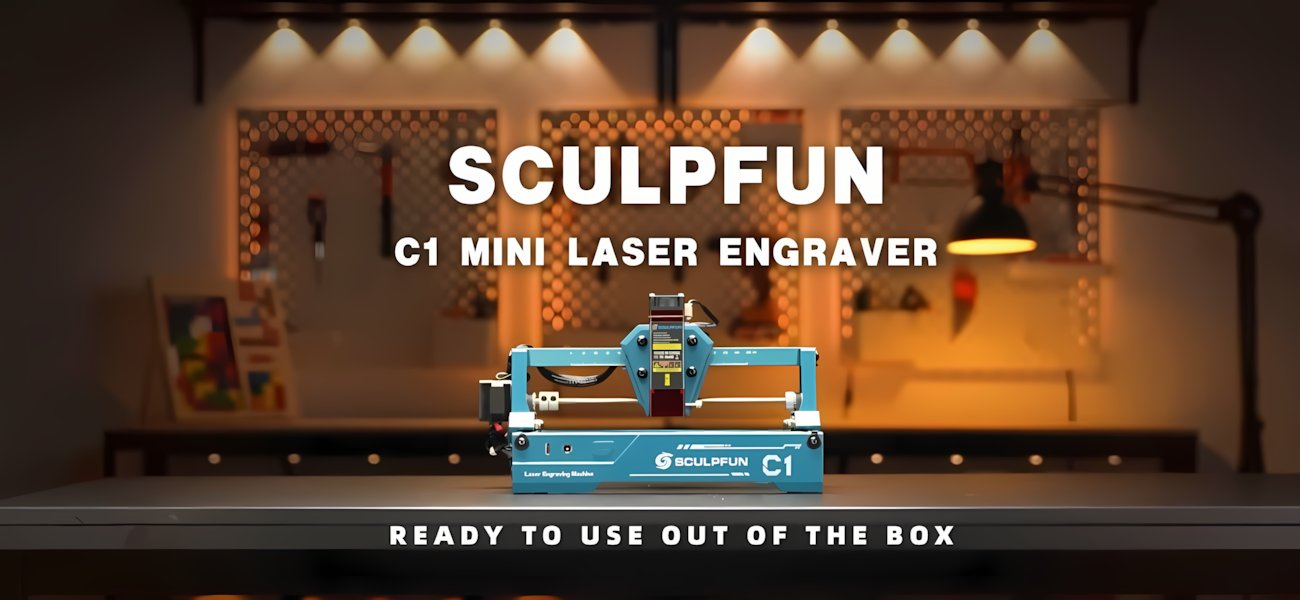 Настільний міні лазерний гравер Sculpfun C1 на робочому столі в майстерні з написом